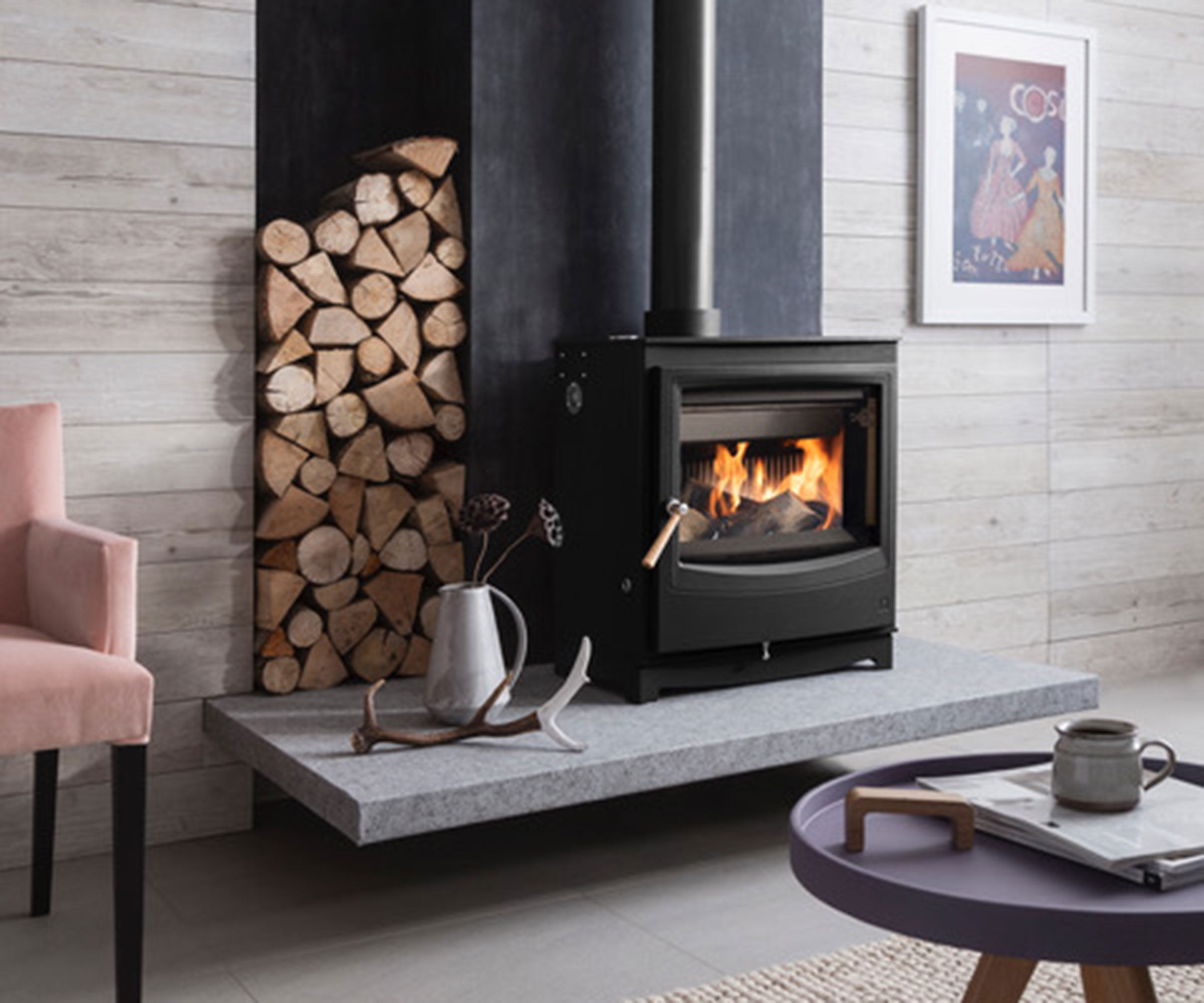 modern log burning stove on raised hearth with log storage built-in to one side