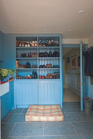 blue built in cabinetry and sink and worktop in mudroom