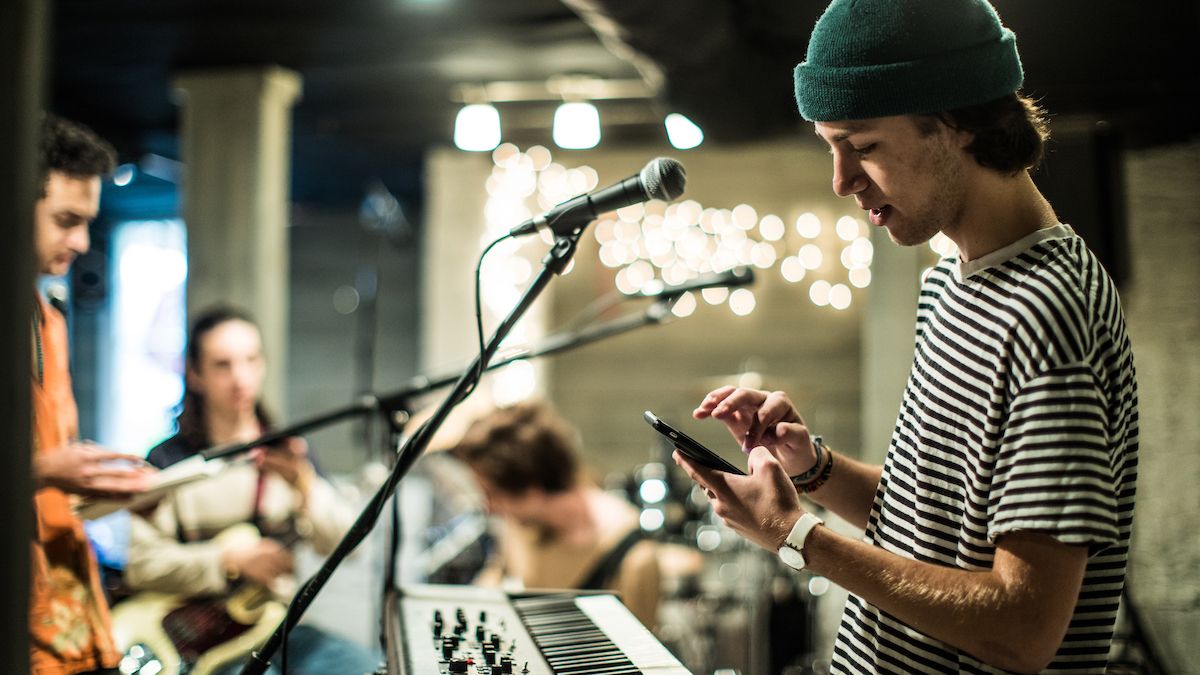 Keyboard player uses his phone