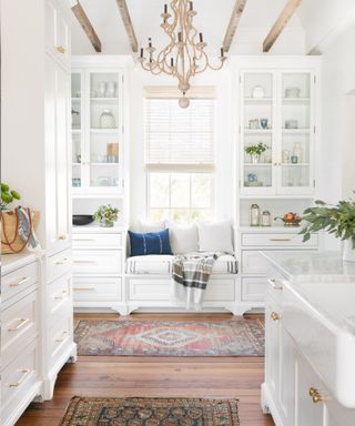 White farmhouse kitchen with a built in window seat by Herlong Architecture and Interiors