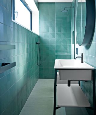 Small bathroom with blue floor to ceiling tiles and shower