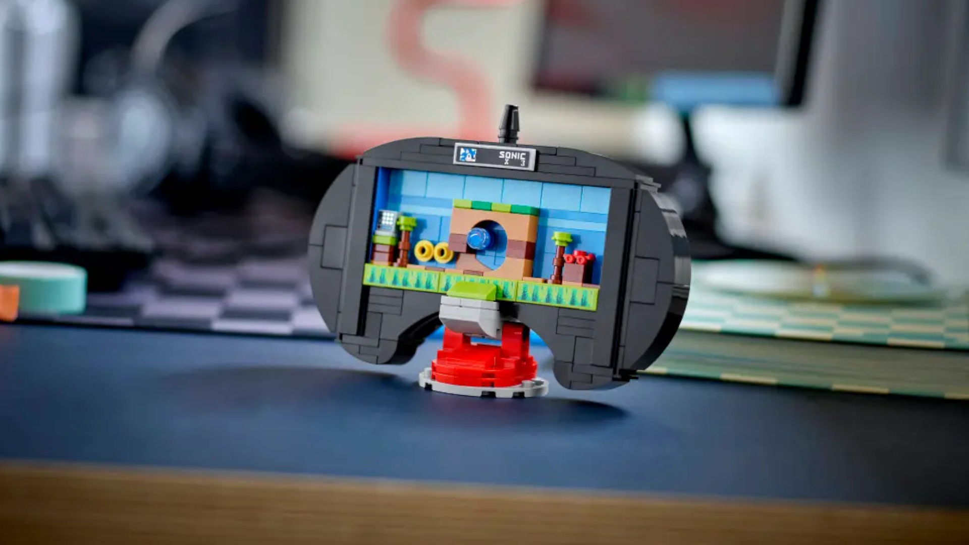 The Lego Sega Genesis Controller set on a blue surface, with the front removed to reveal a Sonic the Hedgehog diorama