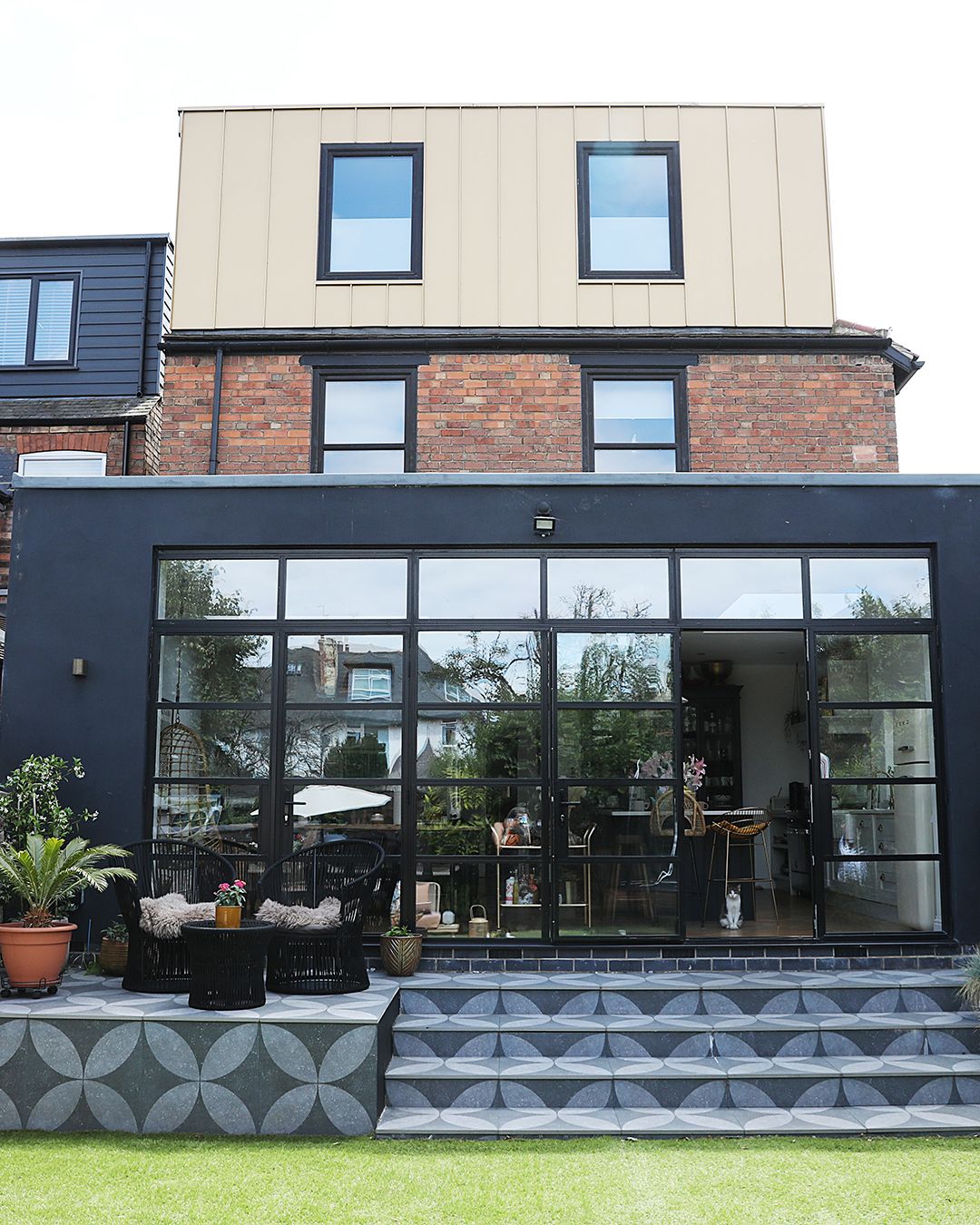 A flat roof kitchen extension with roof glazing and crittal style doors opening to the rear garden