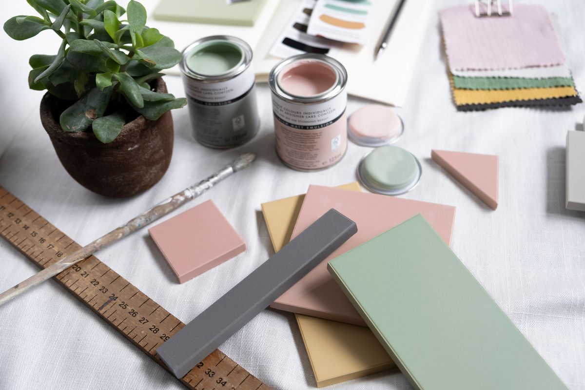 A table top filled with painted tiles and paint pots 