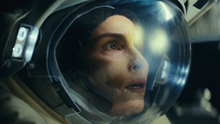 a woman in an astronaut helmet looks frightened