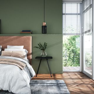 green bedroom with doors to balcony that has blinds