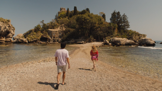 Ethan and Daphne walking along beach to island in The White Lotus