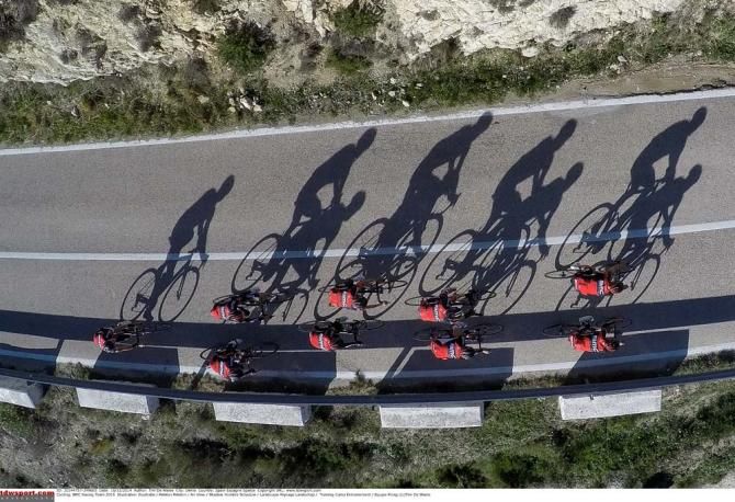 The BMC riders cast long shadows across the road
