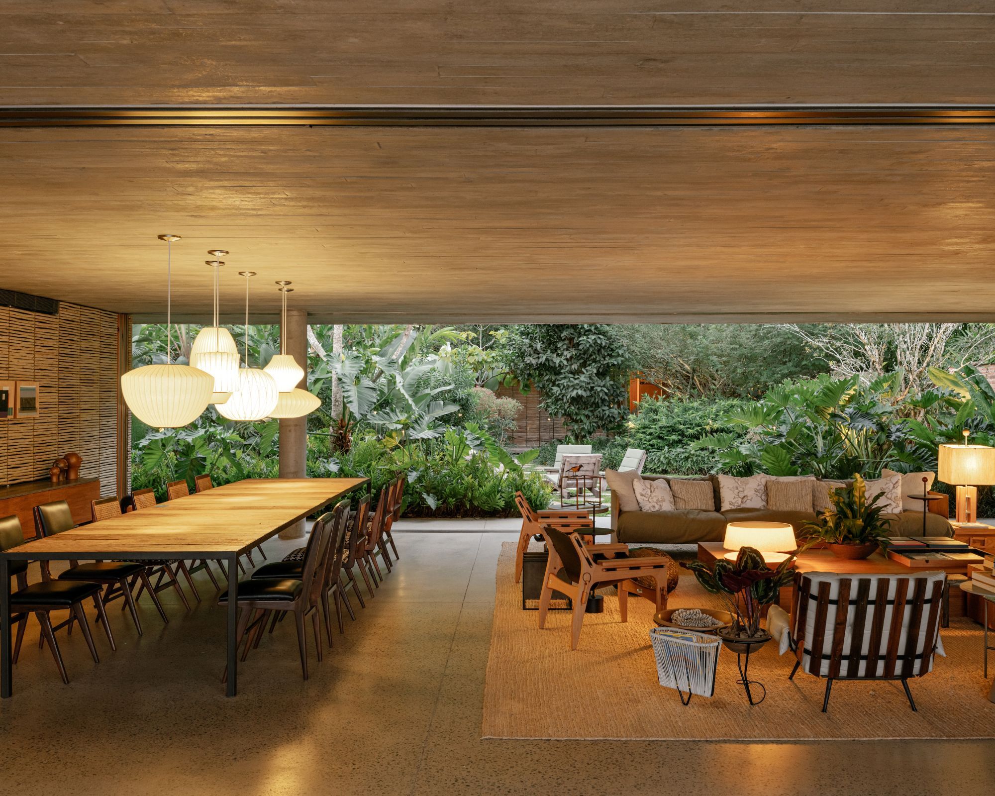 An evening shot of a sitting room with a tropical garden