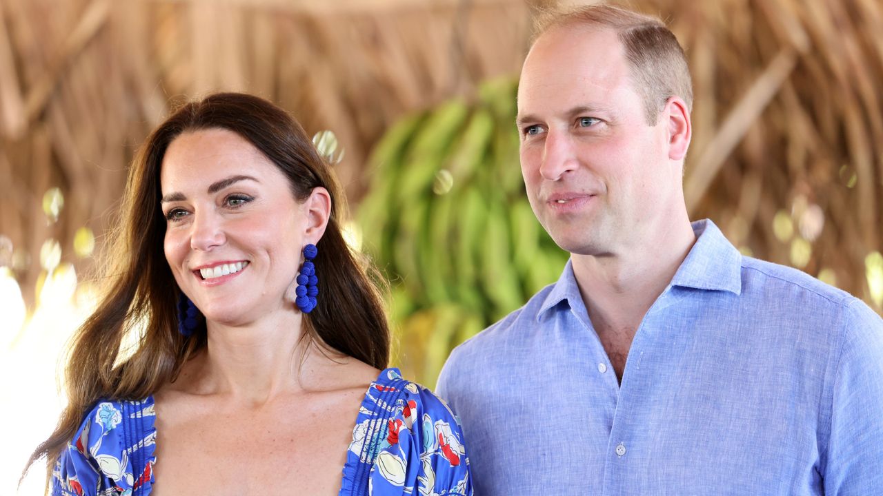 Kate Middleton wearing a blue floral dress and Prince William wearing a blue linen button up shirt with bananas in the background