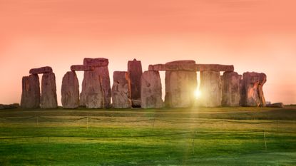 The prehistoric monument of Stonehenge in England with the sun shining through it