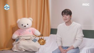 a large teddy bear sits propped next to a gold tea pot as a man (right, cha seo-won) sits in a chair, in the korean show 'i live alone'