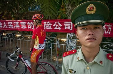 A member of the Chinese National Armed Services wasn't going to let anyone get too close to China 361 Team rider Chen Yuanjun in Dongfang.