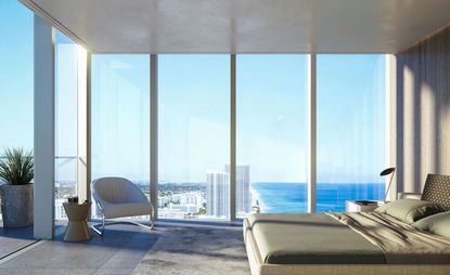 master bed room with an ocean and coastal view through floor to ceiling windows in Florida