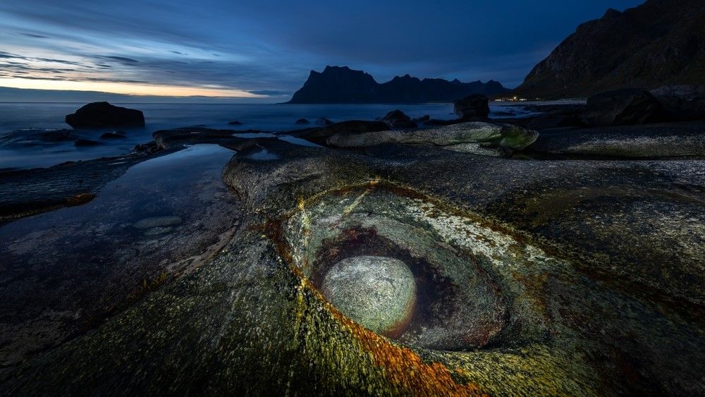 The Dragon Eye at dusk with the surrounding bay in the background. The eye is lit for the photograph.