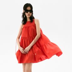 model wears short 4 tiered red dress and red sandals and black sunnies