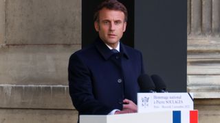 Emmanuel Macron addressing people from a lectern.