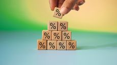 Wooden blocks with a percentage symbol on them form a pyramid.