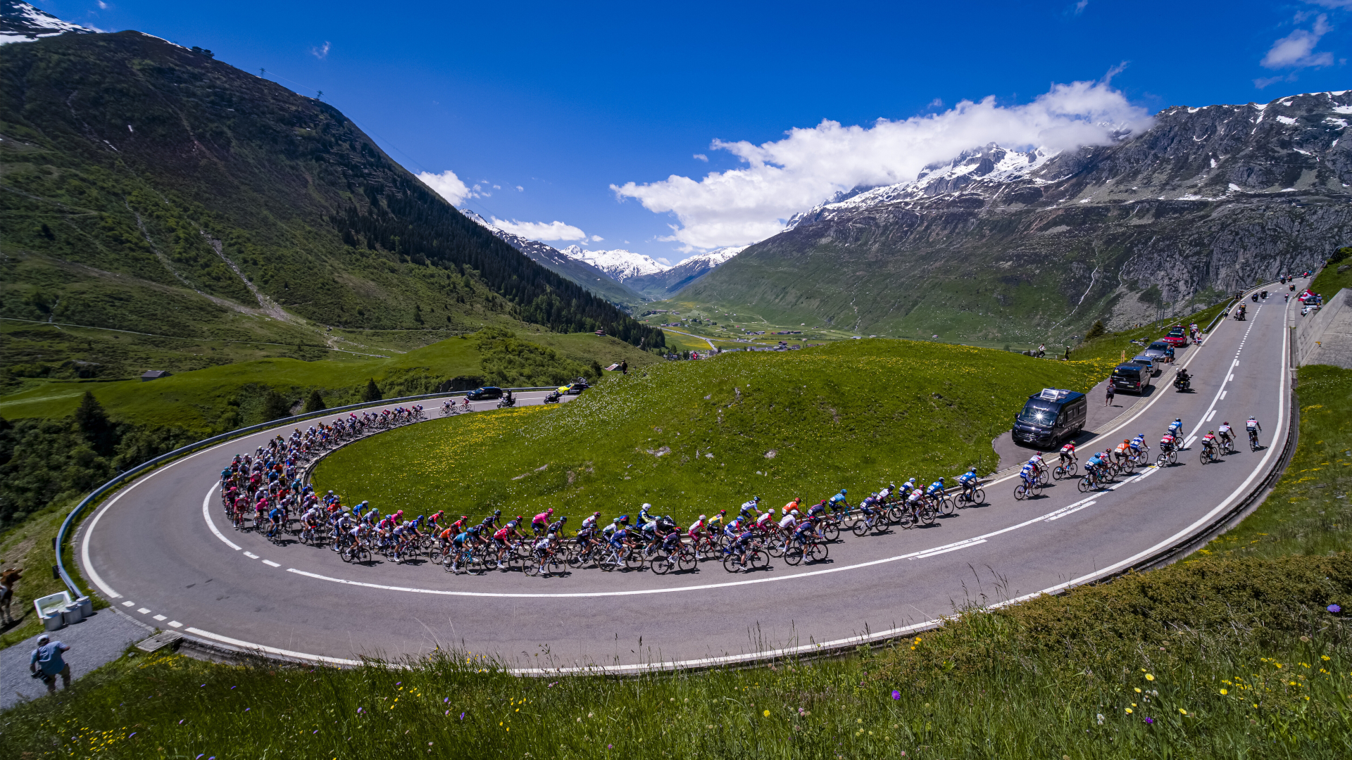 Tour de Suisse peleton around a huge mountain bend