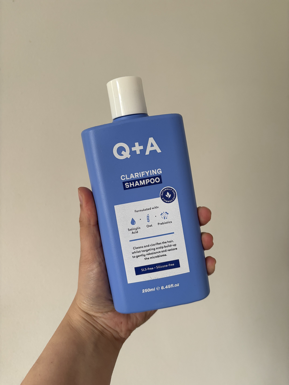 Mica Ricketts holding Q+A Clarifying Shampoo