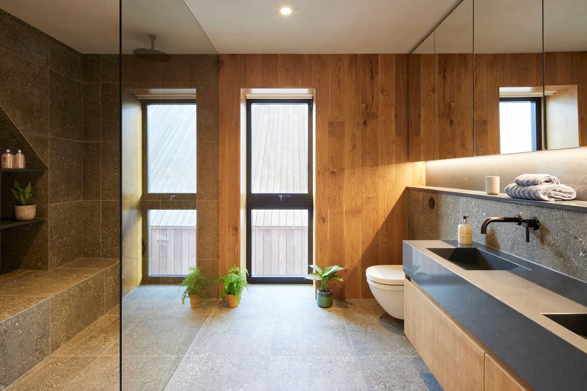 The bathroom with walk in shower to the left and large sink and toilet to the right