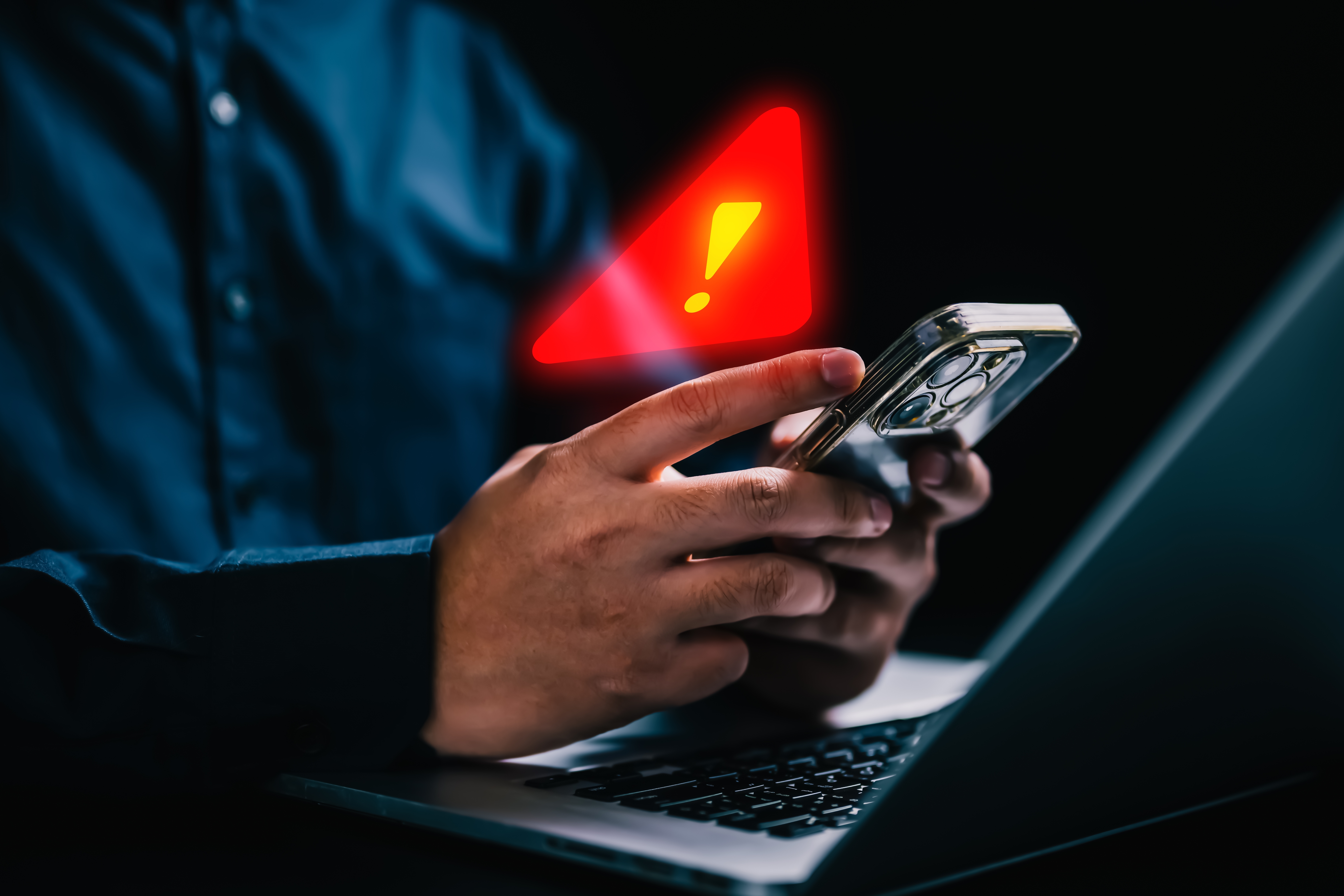 Person with warning notification and spam message icon on mobile phone