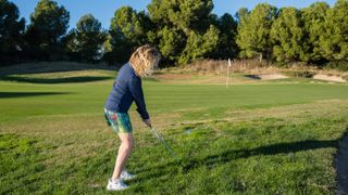 Female golfer chipping