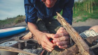 Man Lighting A Campfire On The Beach