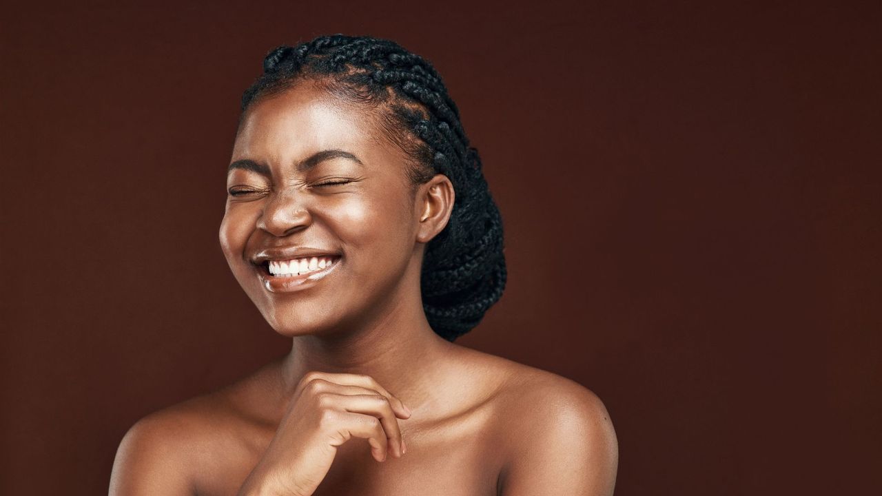 best toner - black model smiling with eyes shut and glowy skin