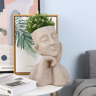 statue planter with a plant