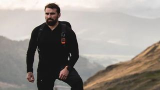 Man hiking in the mountains wearing Garmin Fenix 6 watch