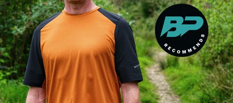 A man wearing the Madison Flux Trail Short Sleeve Jersey by a trail