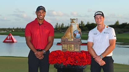 Tiger Woods and Viktor Hovland pose next to the Hero World Challenge trophy