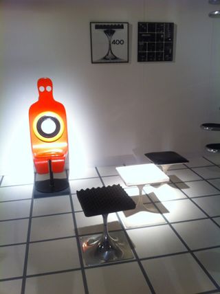 Black and white tables with orange seat resembling a human behind