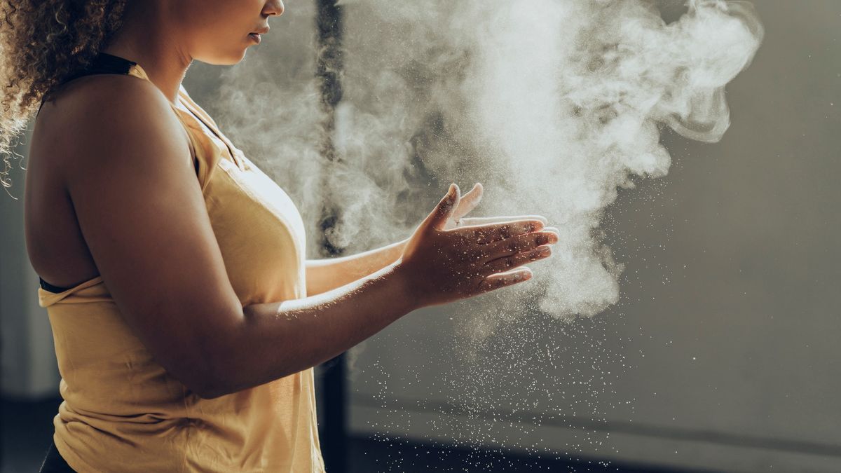 a photo of a woman clapping her hands with chalk before exercising