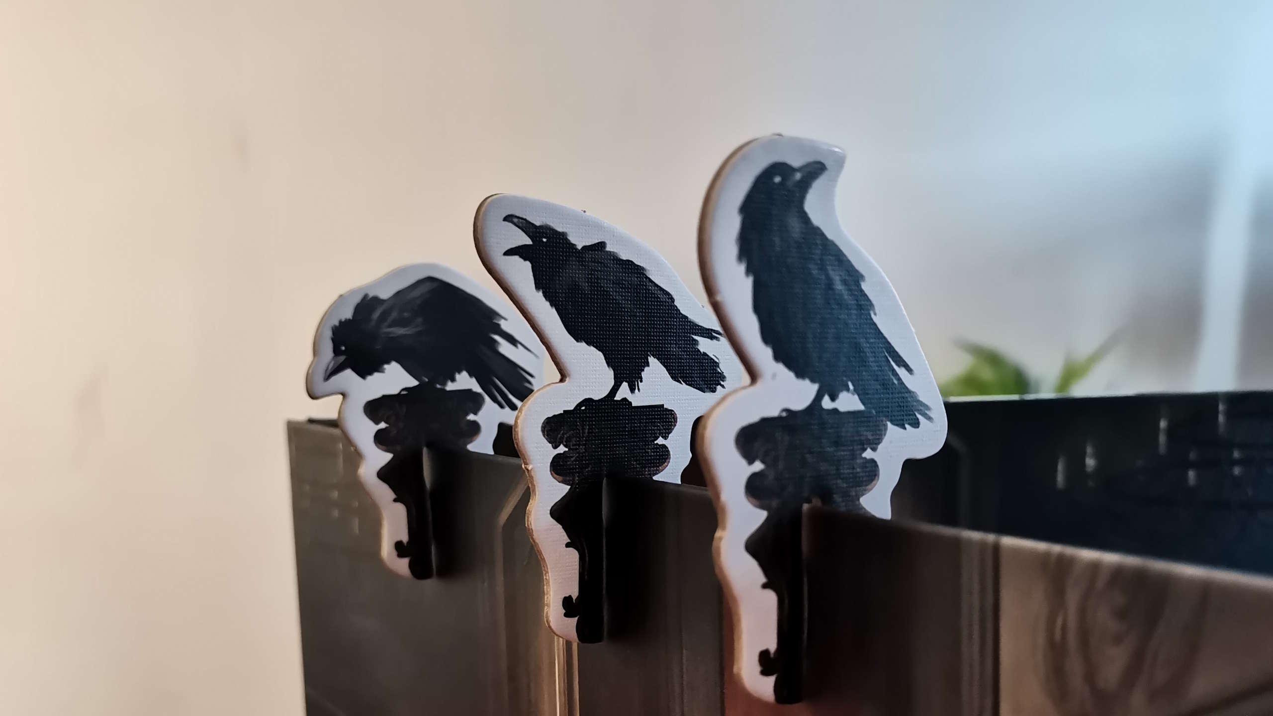 Cardboard raven tokens along a board