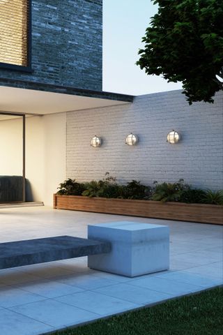 How to position landscape lighting with industrial flush lights on a white garden wall