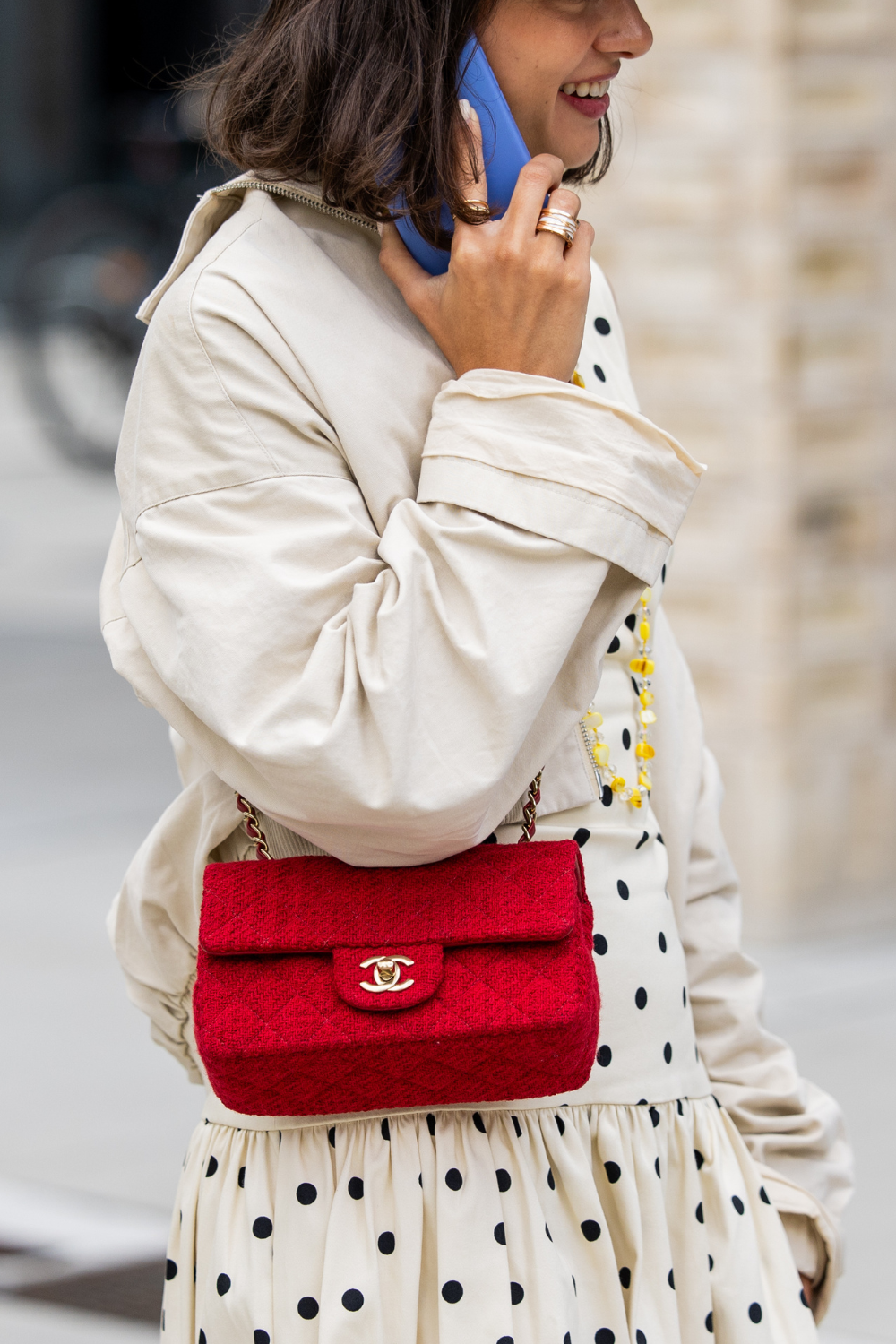 A guest wears red Chanel crossbody bag, baker boy hat outside Herskind during Copenhagen Fashion Week