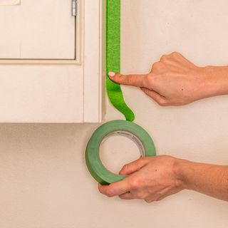 masking tape with cabinet and hand