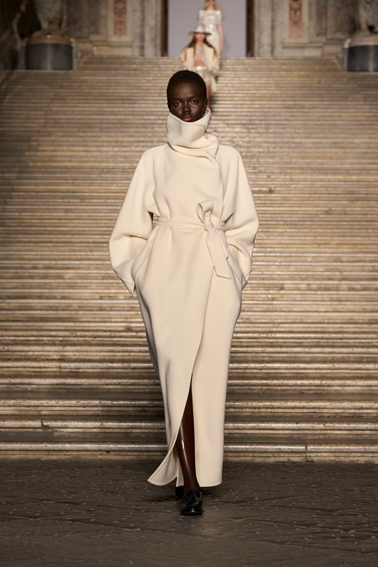 A model wore a white coat on the Max Mara Resort 2026 runway