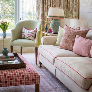Living room with sofa, armchair and upholstered ottoman on rug