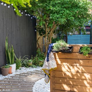 garden area with potted plants and grey fence