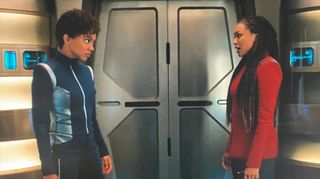 in a scene from the tv show star trek: discovery, two women star at each other while standing on the deck of a spaceship