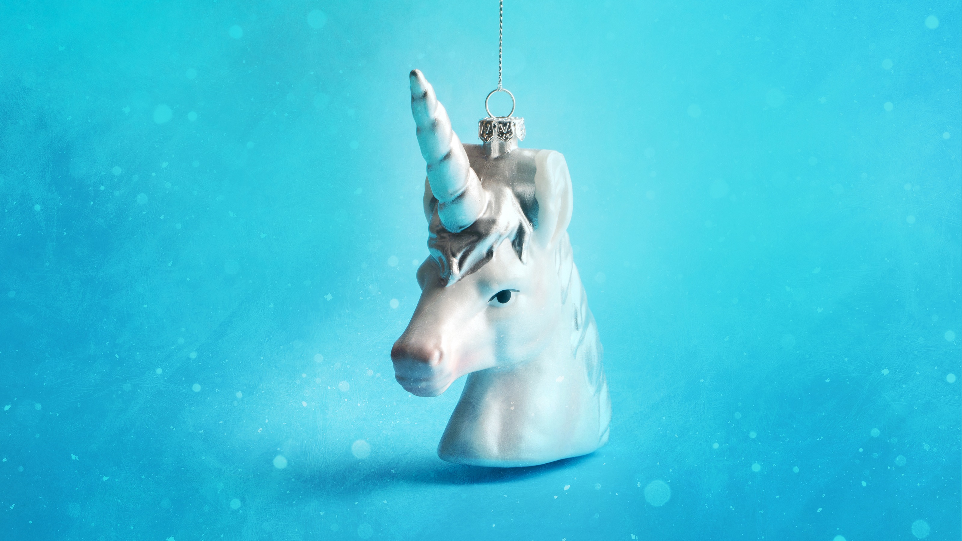A unicorn Christmas ornament against a blue background.