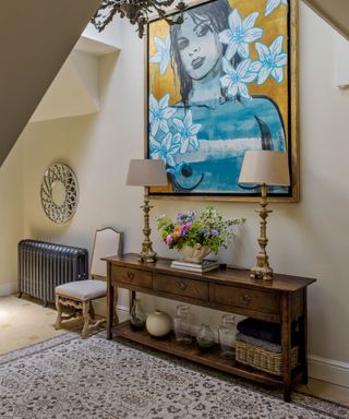 An example of how to make a narrow hallway look wider, with an antique console and large artwork.