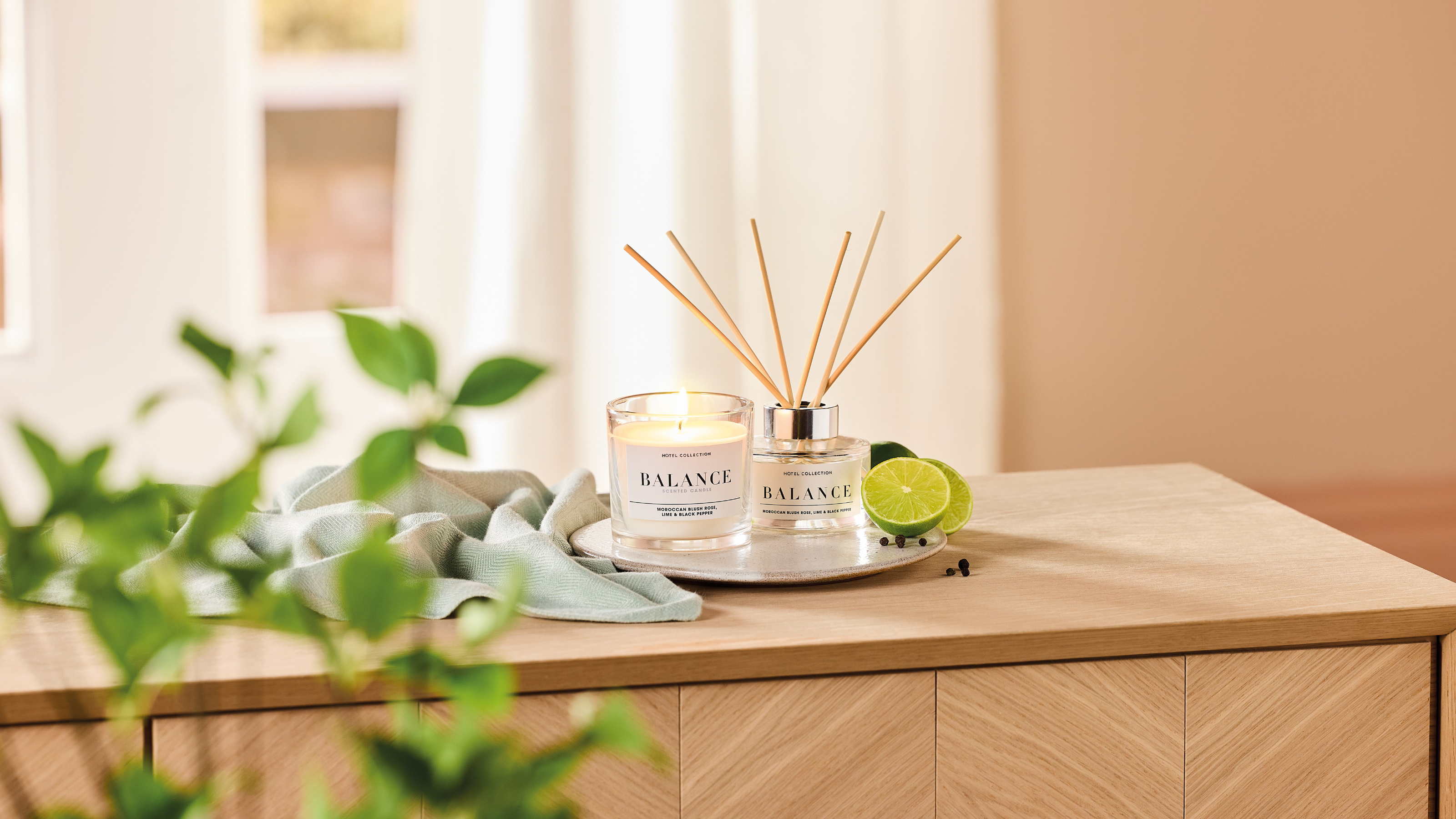 Aldi Balance candle and reed diffuser on wooden sideboard.