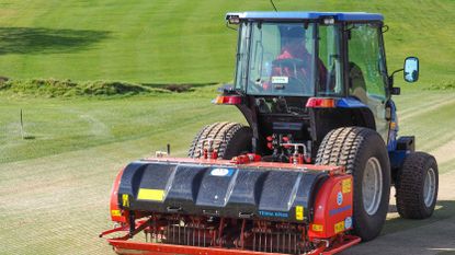 A greenkeeper aerating the greens at a golf course in Ipswich 