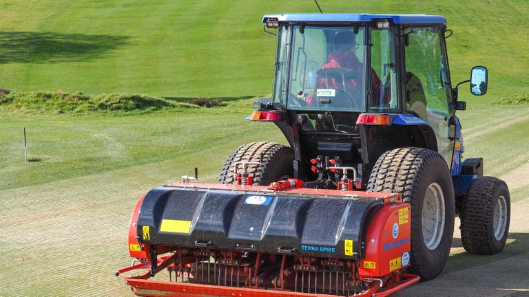 A greenkeeper aerating the greens at a golf course in Ipswich 