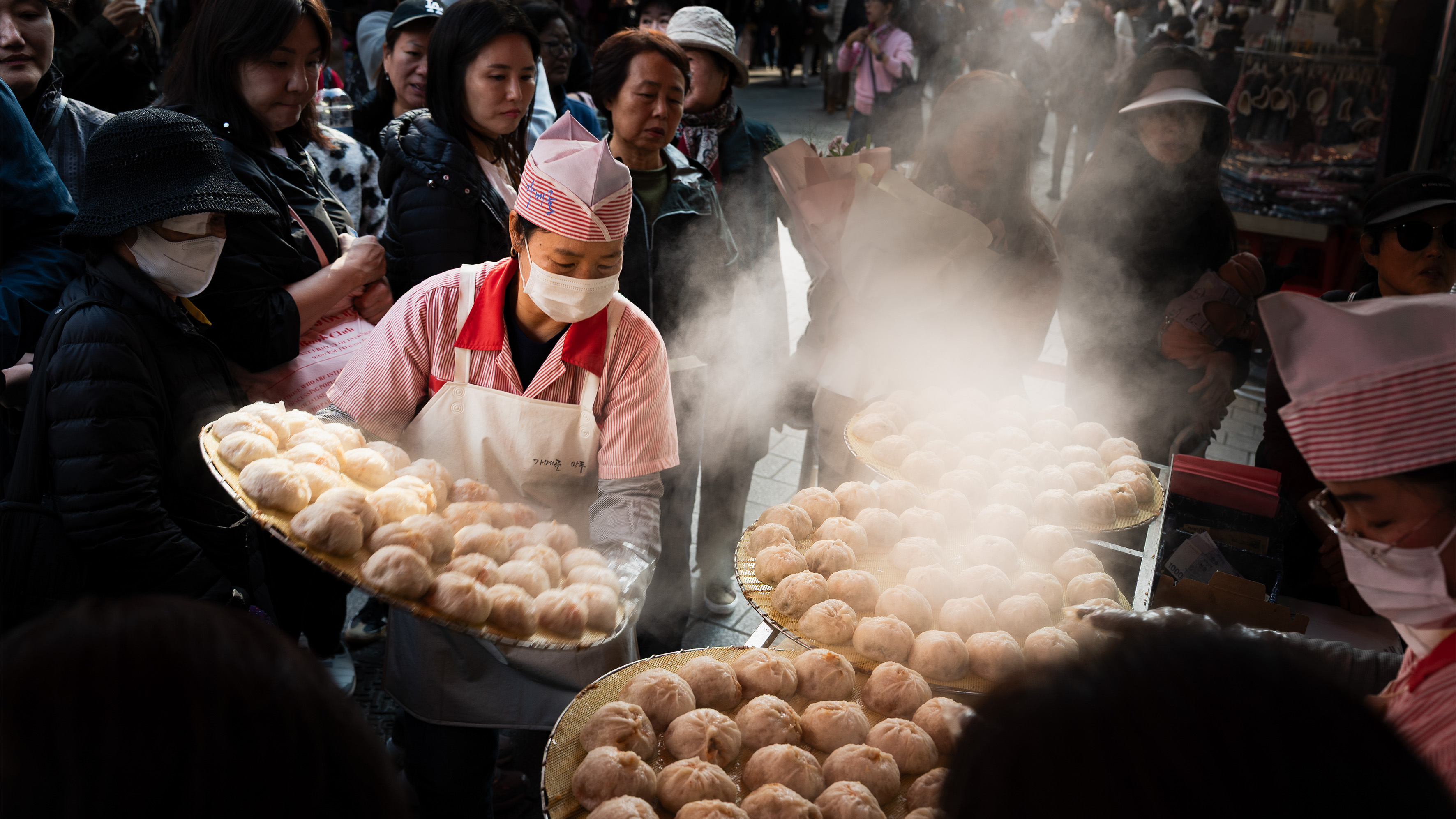 Steaming trays of dumplings in a market. 