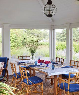 outdoor dining room with cane furniture and windows all round